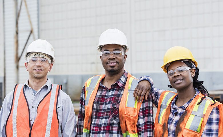Three construction workers in hardhats and safety vests