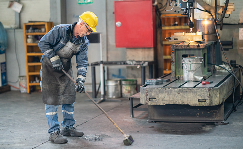 Worker cleaning industrial dirt